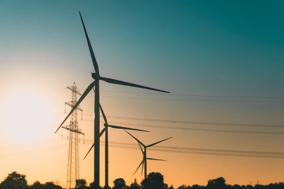 Picture of wind turbines with powerlines in the background illustrating applications of Operational Technology